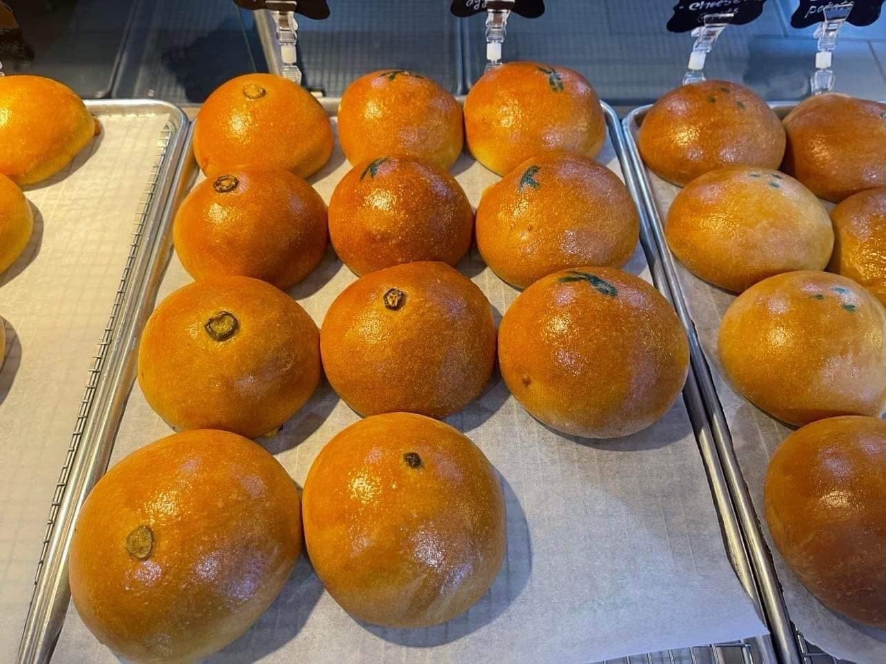Rows of golden kolaches with handwritten labels in the display case