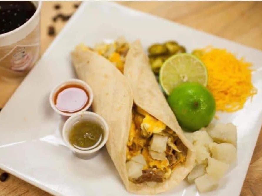 Potato, sausage, egg and cheese breakfast taco with salsa, jalapeños, lime and shredded cheese